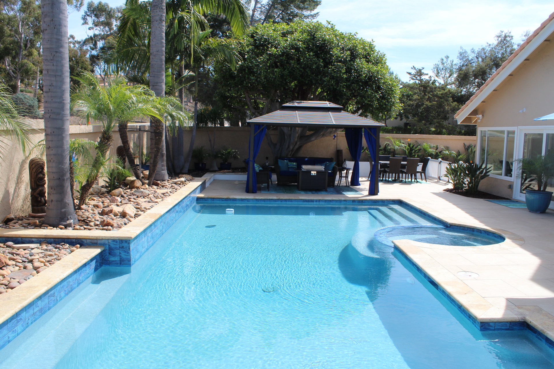 Wide view of the pool, cabana and house across the backyard