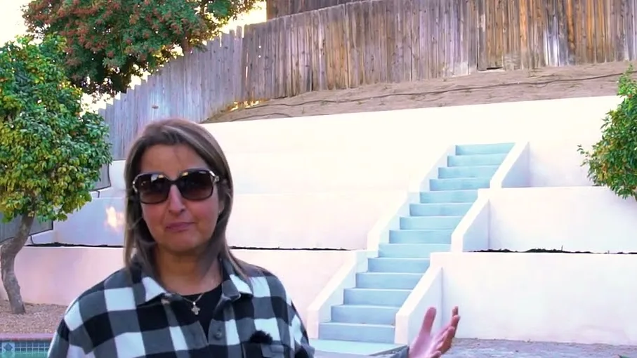 Homeowner on camera in front of new white terraced retaining walls and stairs above a Santee pool